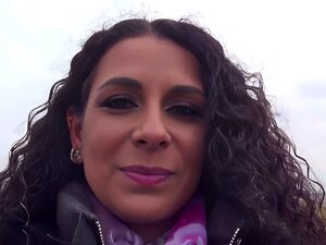 Une allemande aux cheveux noirs avec de longs cheveux bouclés suce la