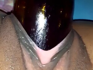 Grand arraché noir frappant et sortant une bouteille du vagin