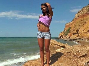 Magdeline s'assoit sur son short pour se masturber sur le rivage