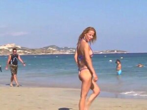 MILF blonde chaude posant sur une plage publique en bikini string.