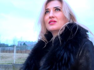 Blonde en manteau suce une énorme bite en extérieur pour un agent