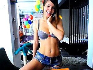 Beauté brune en short en jean et soutien-gorge bleu exhibe son