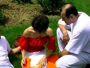 Une brune poilue se fait baiser le cul par deux mecs dans le jardin de
