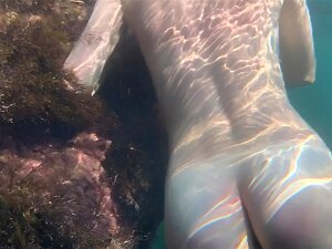 Fille nue nage dans la mer et se caresse sous l'eau