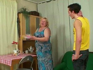 La belle-mère aux gros seins suce et chevauche une nouvelle bite